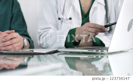 Female doctor showing medical exam results on a laptop to a patient during a visit at the clinic, healthcare and medical consultation concept Female doctor showing medical exam results on a laptop to a patient during a visit at the clinic, healthcare and medical consultation concept 123730147