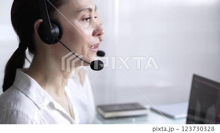 Adult female call center operator in assisting clients online, providing customer support and answering inquiries. Business call center concept 123730328