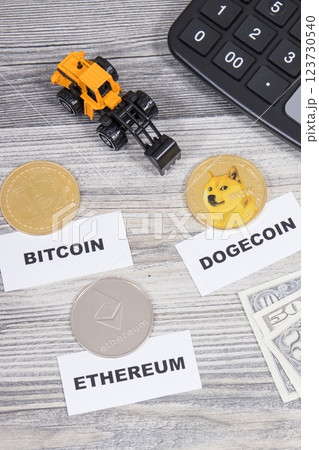 Cryptocurrency coins, dollar bills, miniature excavator and calculator Cryptocurrency coins, dollar bills, miniature excavator and calculator 123730540
