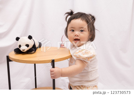 【テーブルでつかまり立ちをするツインテールの赤ちゃん】 【テーブルでつかまり立ちをするツインテールの赤ちゃん】 123730573