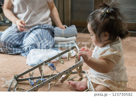 【洗濯ハンガーを触るツインテールの赤ちゃん】 123730582