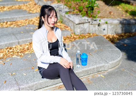 川沿いの道をウォーキングの途中で座って休憩するかっこいい女性 エクササイズ 有酸素運動 散歩 川沿いの道をウォーキングの途中で座って休憩するかっこいい女性 エクササイズ 有酸素運動 散歩 123730845