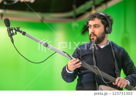 Boom microphone operator testing sound at TV studio. 123731303