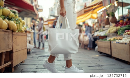 A woman is walking down a street with a white shopping bag 123732713