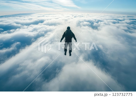 A Gliding Skydiver Surrounded by Fluffy Clouds in a Bright Blue Sky 123732775