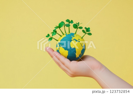 A hand holding a globe with green plants on it. Concept of taking care of the environment and the importance of preserving the earth A hand holding a globe with green plants on it. Concept of taking care of the environment and the importance of preserving the earth 123732854