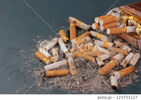 image of several commercial cigarettes with cigarette packs. pile of cigarettes on turquoise floor or No smoking, tobacco campaign concept. image of several commercial cigarettes with cigarette packs. pile of cigarettes on turquoise floor or No smoking, tobacco campaign concept. 123733127