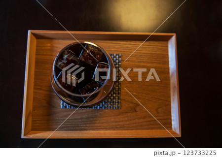 Top view of ice Americano black coffee on wooden cafe table Top view of ice Americano black coffee on wooden cafe table 123733225