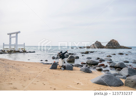 Japanese young people in victory hand gesture selfie at Sakurai Futamigaura couple stones, Itoshima 123733237