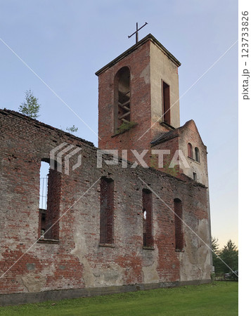 The bell tower with a cross rises above ruins of an old church, 123733826