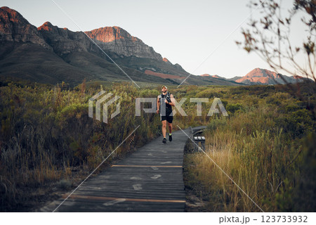 Health, man runner and in nature for training, wellness and fitness outdoor in the morning in sportswear. Exercise, male athlete, running on trail and workout warm up to be healthy and do cardio. 123733932