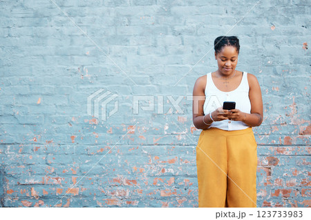 Black woman, fashion and phone by mock up wall in Nigerian city for marketing, advertising or sales deal promotion mockup. Smile, happy or trend student with mobile technology for social media search 123733983