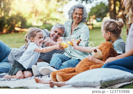 Family, cheers with juice and a picnic in park on happy summer weekend with smile. Grandma, grandpa and mother with girl children relax, celebrate outdoor fun and quality time together in Australia. 123733986