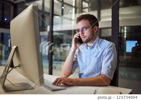 Business, communication and overtime, phone call and man with computer at desk. Late night at office, working on deal or project. Corporate worker in glasses, typing online and talking on smartphone. 123734004
