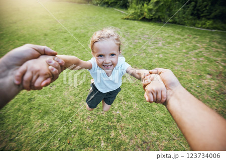 Hands, park smile and girl swinging with support from family in green nature together in summer. Portrait of young child playing, being funny and excited in a circle on the grass in a green garden 123734006