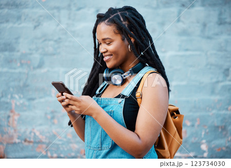 Black woman, smile and phone of a student from Jamaica with technology and headphones. Happy, urban and gen z person using 5g internet, web and social media app scroll while texting with happiness Black woman, smile and phone of a student from Jamaica with technology and headphones. Happy, urban and gen z person using 5g internet, web and social media app scroll while texting with happiness 123734030