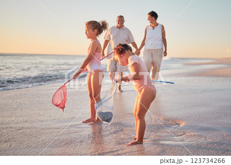 Grandparents and children at the beach with fishing nets and having fun. Young kids and senior couple enjoying holiday with grandkids and retirement together. Playing by the sea in summer with family 123734266