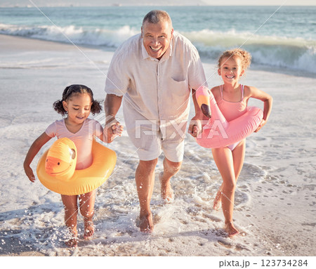 Children, beach and family with a girl, grandfather and sister playing on the sand by the sea or ocean in summer. Water, travel and fun with a grandparent, grandchild and sibling outdoor on holiday 123734284