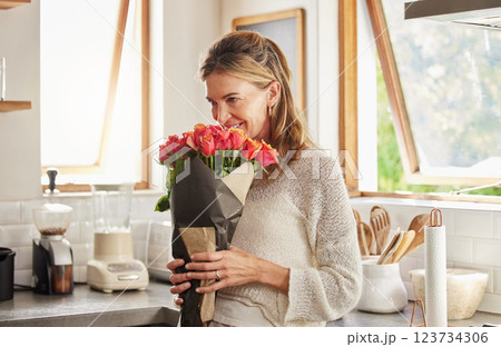 Flowers, smile, and elderly woman smelling rose in a kitchen, surprised by sweet gesture and or secret gift. Happy, romantic and kind surprise for mature, excited woman on valentines morning 123734306