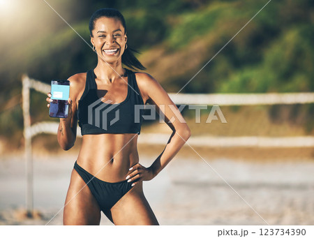 Beach, technology and fitness app, woman with phone in the sand and summer sun. Exercise, bikini and sports workout on holiday in Brazil, happy and girl at volleyball net with mobile application. Beach, technology and fitness app, woman with phone in the sand and summer sun. Exercise, bikini and sports workout on holiday in Brazil, happy and girl at volleyball net with mobile application. 123734390