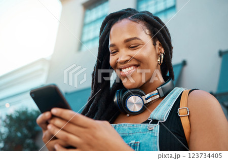 Black woman with a phone in the city, search for online podcast or radio, happy looking for music to listen to. Freedom, relax and smile by African American female enjoying free time and streaming 123734405