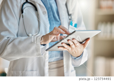 Doctor, office and tablet for research, email or communication. Medic, hospital and reading article, data or health magazine on web, while working with technology in healthcare center or clinic 123734491