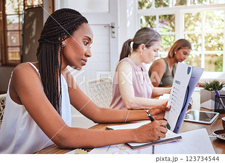 Black woman with business documents, writing at desk and women working together on audit report at startup. Diversity, teamwork and success, reading small business project proposal and taking notes. 123734544