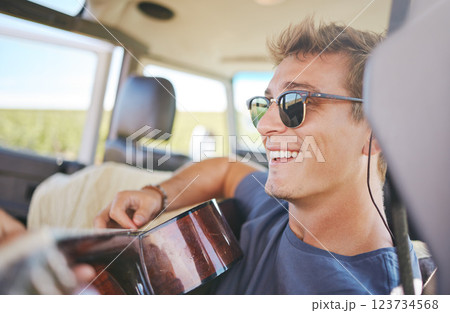 Music, guitar and young man in car on a roadtrip adventure in nature. Summer, holiday and journey on the road, fun musician on vacation. Travel, freedom and explore nature with musical instrument 123734568