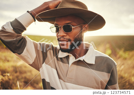 Farm, agriculture and sustainability with a black man in a field, meadow or grass while farming in nature. Farmer, agricultural and sustainable with a young male working on land for organic produce Farm, agriculture and sustainability with a black man in a field, meadow or grass while farming in nature. Farmer, agricultural and sustainable with a young male working on land for organic produce 123734571