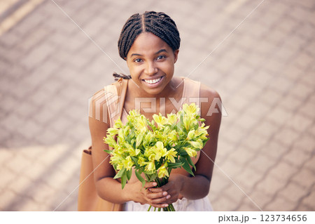 Flowers, gift and black woman with smile for bouquet for birthday or celebration in the street from above. Face of an African girl with a present of yellow lilies in the road and the city of France Flowers, gift and black woman with smile for bouquet for birthday or celebration in the street from above. Face of an African girl with a present of yellow lilies in the road and the city of France 123734656