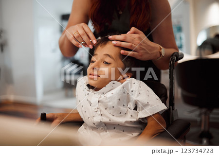 Hairdresser, child with disability and wheelchair with hairstylist cutting his hair at salon. Young kid with cerebral palsy in Mexico getting professional haircut with scissors from beautician woman 123734728
