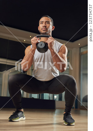 Workout, squat and kettlebell with man in gym for exercise, muscle and health. Fitness class, weights and sports center with male person training in studio for wellness, athlete and challenge 123734737