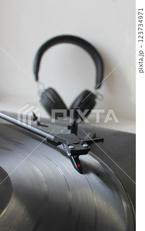 Blurred Wireless Headphones Behind Vinyl Disc Of Classic Turntable 123734971