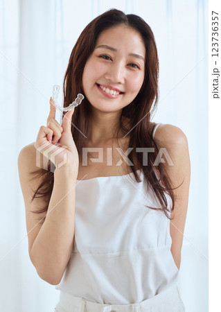 マウスピース矯正を持つ女性 マウスピース矯正を持つ女性 123736357