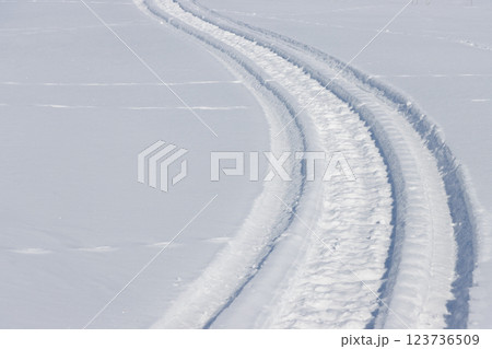 雪面に残るスノーモビールの跡 123736509