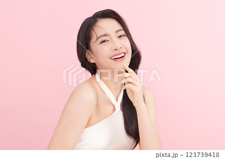 A beautiful young Asian woman with clean, fresh skin against a pink background. Skincare, facial treatment, cosmetology, beauty, and spa. An elegant portrait of an Asian woman. A beautiful young Asian woman with clean, fresh skin against a pink background. Skincare, facial treatment, cosmetology, beauty, and spa. An elegant portrait of an Asian woman. 123739418