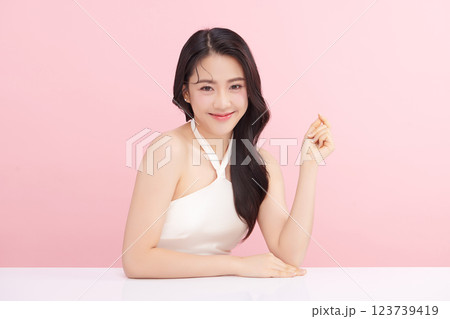 A beautiful young Asian woman with clean, fresh skin against a pink background. Skincare, facial treatment, cosmetology, beauty, and spa. An elegant portrait of an Asian woman. A beautiful young Asian woman with clean, fresh skin against a pink background. Skincare, facial treatment, cosmetology, beauty, and spa. An elegant portrait of an Asian woman. 123739419