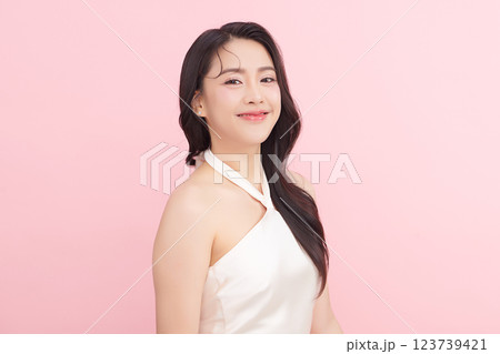 A beautiful young Asian woman with clean, fresh skin against a pink background. Skincare, facial treatment, cosmetology, beauty, and spa. An elegant portrait of an Asian woman. A beautiful young Asian woman with clean, fresh skin against a pink background. Skincare, facial treatment, cosmetology, beauty, and spa. An elegant portrait of an Asian woman. 123739421