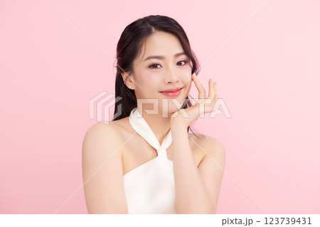 A beautiful young Asian woman with clean, fresh skin against a pink background. Skincare, facial treatment, cosmetology, beauty, and spa. An elegant portrait of an Asian woman. A beautiful young Asian woman with clean, fresh skin against a pink background. Skincare, facial treatment, cosmetology, beauty, and spa. An elegant portrait of an Asian woman. 123739431