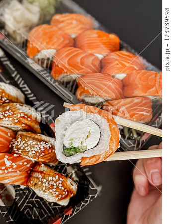 Japanese sushi rolls with salmon, avocado and cream cheese on black background, close-up.  123739598