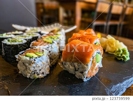 Japanese sushi rolls with salmon, avocado and cream cheese on black background, close-up.  123739599