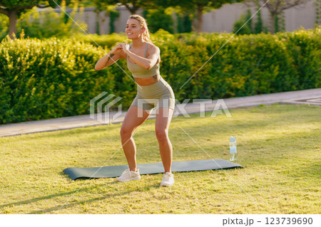 A Woman Engaging in Exercising Outdoors on a Yoga Mat for a Healthy Lifestyle and Fitness 123739690