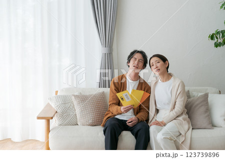 督促状の封筒を見て困る夫婦 123739896