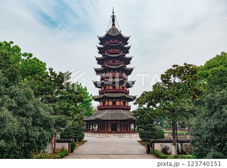 A multi-tiered pagoda rises majestically with intricate wooden architecture, surrounded by lush greenery. A multi-tiered pagoda rises majestically with intricate wooden architecture, surrounded by lush greenery. 123740151