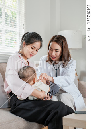 Pediatrician checks baby's health while mother watches in cozy living room, highlighting home healthcare. Pediatrician checks baby's health while mother watches in cozy living room, highlighting home healthcare. 123740166