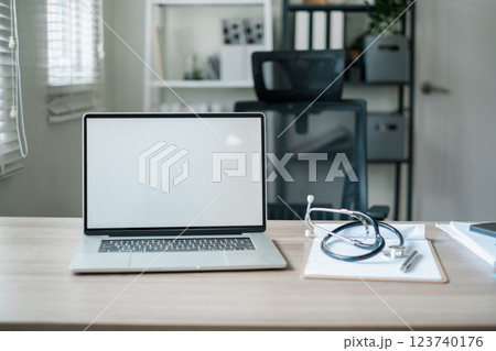 A clean and modern office desk setup featuring a laptop and stethoscope, ideal for medical or professional themes. A clean and modern office desk setup featuring a laptop and stethoscope, ideal for medical or professional themes. 123740176