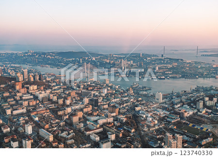Aerial cityscape of Vladivostok at sunset showcasing urban development and the famous bridges connecting urban areas 123740330