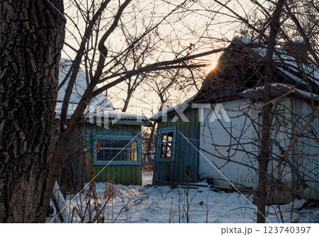Winter sunset illuminating abandoned buildings in a rural setting with snow-covered ground. Winter sunset illuminating abandoned buildings in a rural setting with snow-covered ground. 123740397