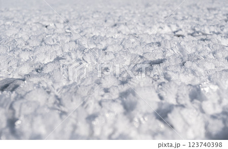 Crystal formations cover a frozen landscape during winter, showcasing intricate designs under bright sunlight. Crystal formations cover a frozen landscape during winter, showcasing intricate designs under bright sunlight. 123740398