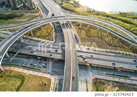 Urban highway interchange showcases modern infrastructure and busy traffic flow in a bustling city environment Urban highway interchange showcases modern infrastructure and busy traffic flow in a bustling city environment 123740423